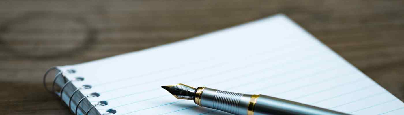 carnet et un stylos posés sur un table, utilises pour ecrire la biographie des personnes en fin de vie en accompagnement en soins palliatifs